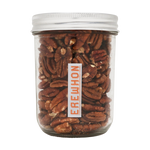 A clear glass jar filled with raw pecans, with a white label that has the brand name 'EREWHON' written on it.