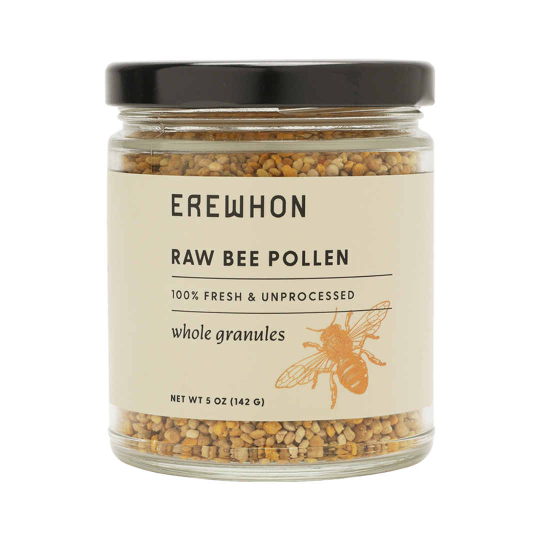A jar of Erewhon Raw Bee Pollen with whole granules visible through the transparent glass. The label displays the brand name and product details.