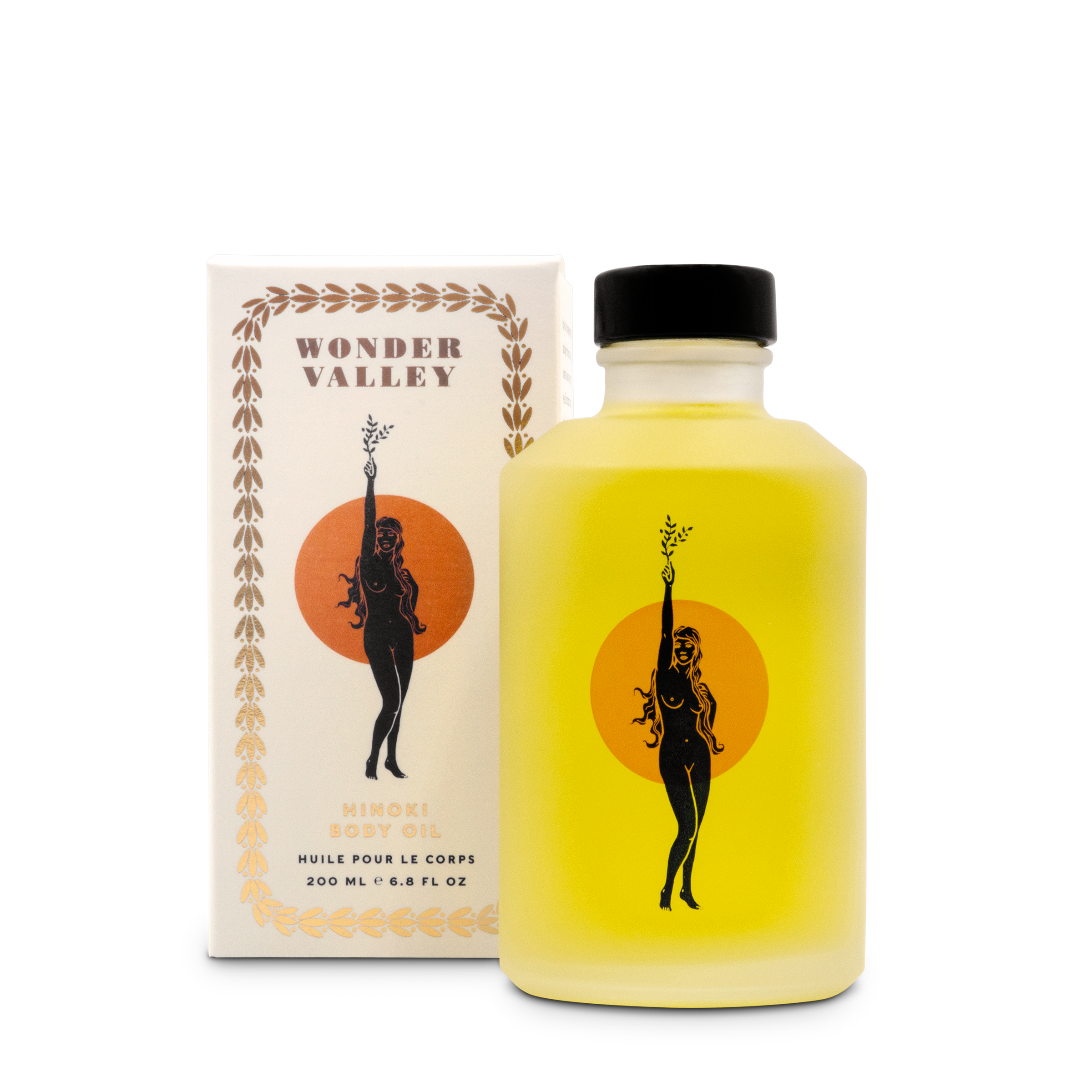 A bottle of Wonder Valley Hinoki Body Oil next to its packaging box. The bottle is filled with a yellow liquid, and the box has a silhouette of a woman and the setting sun.