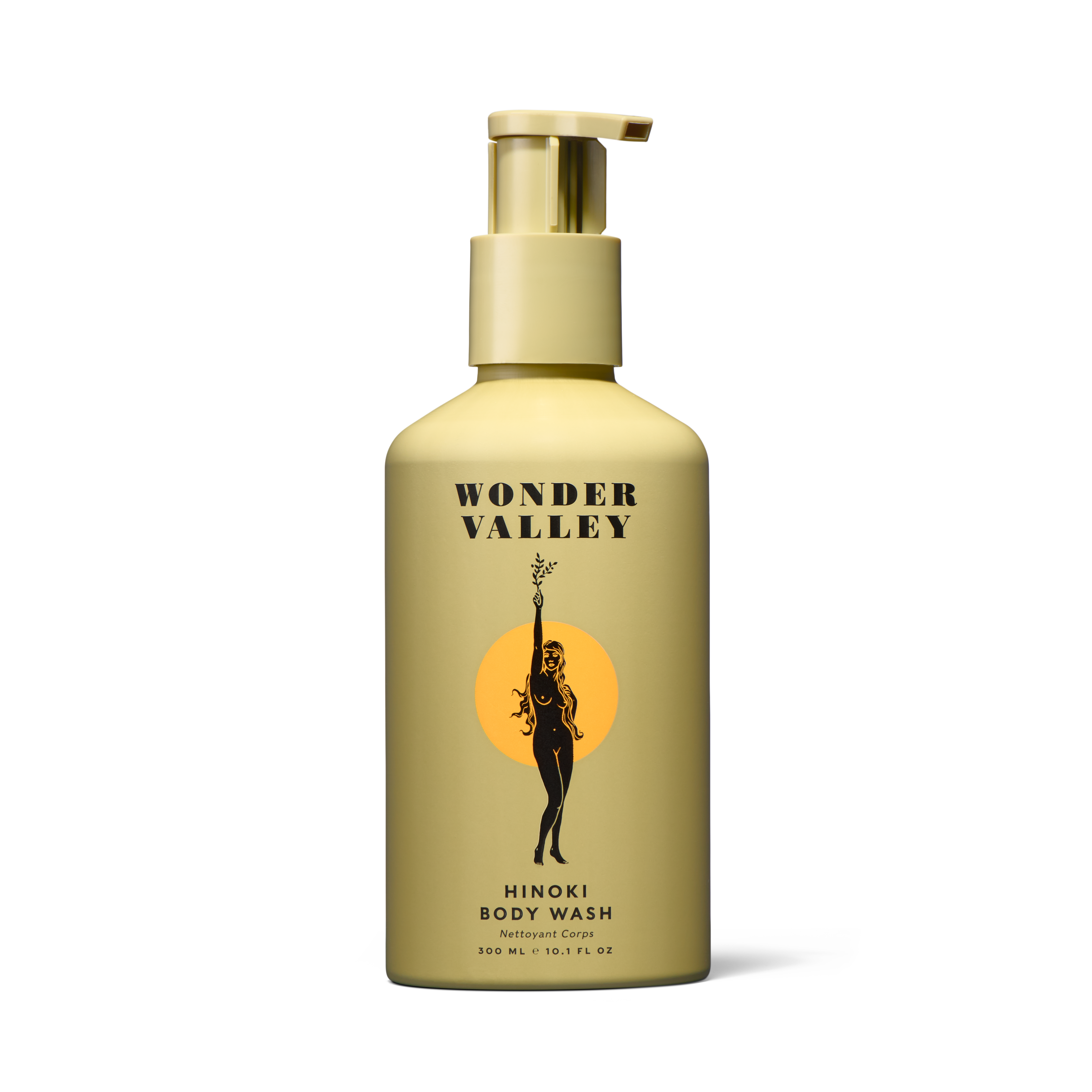 A sleek aluminum bottle with a pump dispenser, labeled 'Wonder Valley Hinoki Body Wash', featuring a design of a figure in a circle and a sun motif.